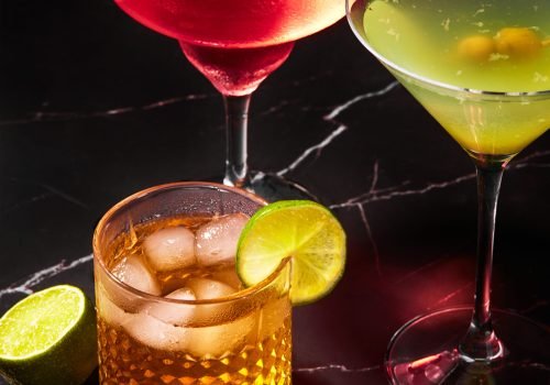Alcoholic and non-alcoholic cocktails on a dark marble table. Summer refreshments.